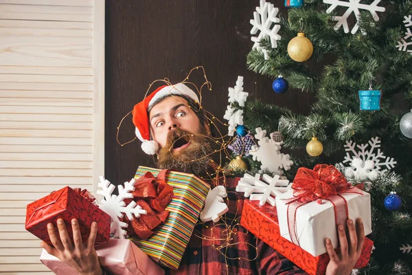 Christmas man with beard on scared face hold gift.