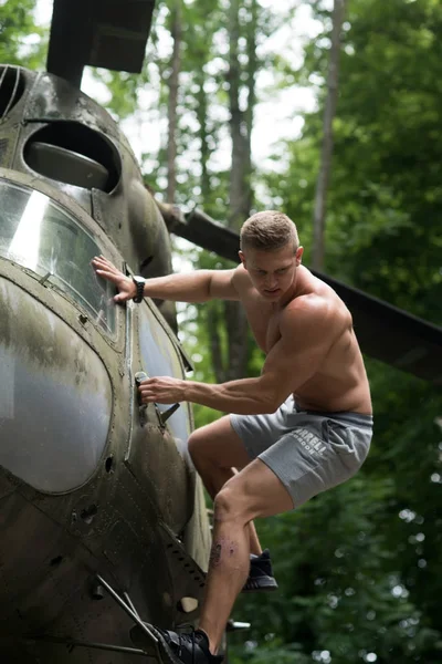 Sportsman with muscle body on heli aircraft — Stock Photo, Image