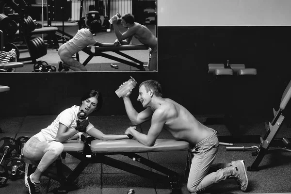 Braccio di ferro muscolare uomo e ragazza in palestra — Foto Stock