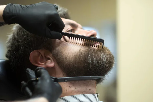 Hipster with serious face in barbershop, new technology.