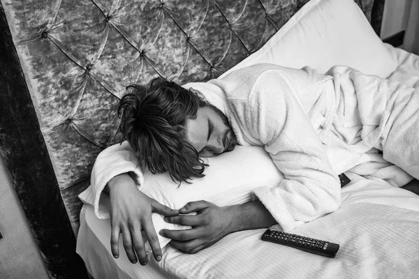 Bearded man on bed with remote — Stock Photo, Image