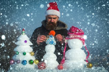 Kar xmas ağacı ve heykeller üzerinde mavi gökyüzü