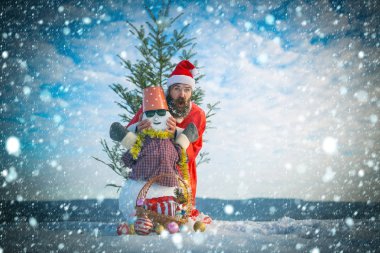 Bulutlu gökyüzü üzerinde karlı heykel ile poz adam