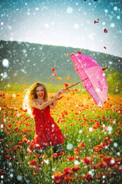 Kırmızı haşhaş alanın üzerinde pembe şemsiye ile mutlu kız