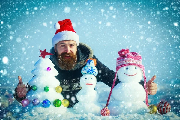 Muñecos de nieve en sombreros y nieve árbol de Navidad en el cielo azul —  Fotos de Stock