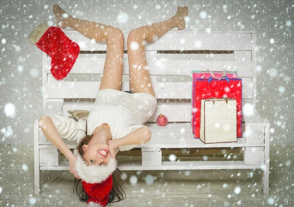 Santa claus menina com presente no banco . — Fotografia de Stock