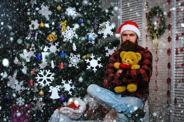 Yeni yıl adam şapka oturup Noel ağacı. — Stok fotoğraf