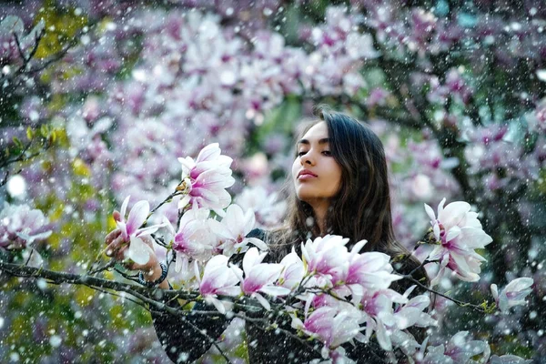 Mujer con el pelo largo y morena posando en magnolia tree —  Fotos de Stock