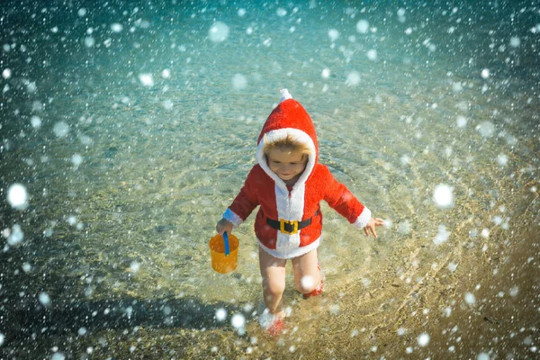 Niño feliz de Navidad con cubo en el agua . — Foto de Stock