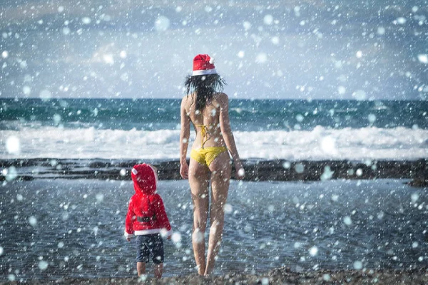 Vrouw en kind permanent op zee strand — Stockfoto