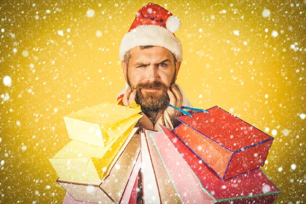 Weihnachten Hipster Shopper mit Stirnrunzeln Gesicht in Weihnachtsmütze — Stockfoto