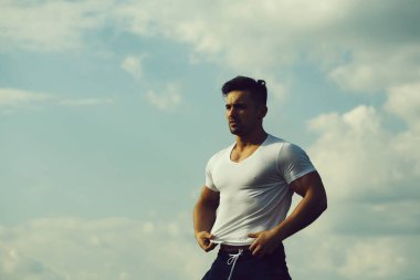Gökyüzü arka plan üzerinde seksi kaslı adam