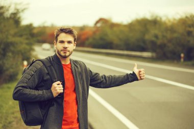 Genç adam otostop çekiyor.