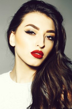 Kırmızı dudaklar ve uzun esmer kıvırcık saçlı seksi kadınla