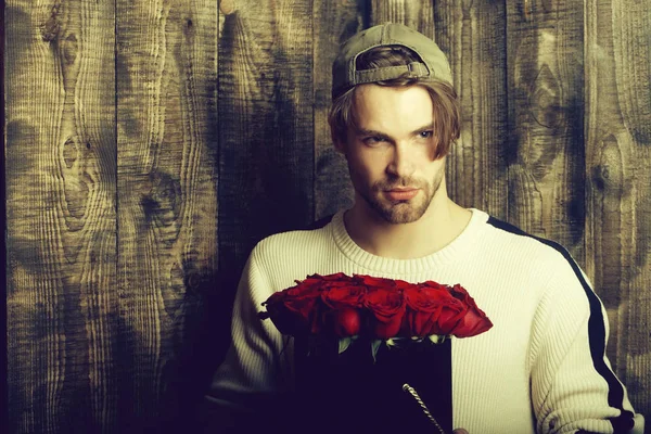 adam tutar kırmızı gül çiçekler kutusunda sakallı