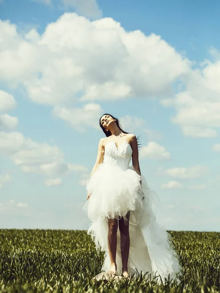 Bonita chica de la boda en hierba verde y el cielo — Foto de Stock