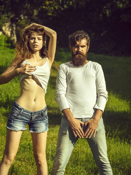 Yeşil çimenlerin üzerinde seksi genç Çift