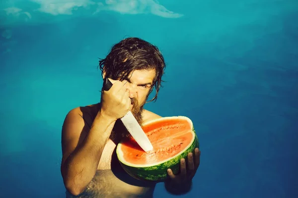 Homme avec pastèque et couteau dans la piscine — Photo