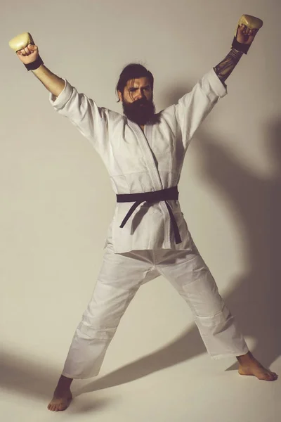 Bearded serious karate man in kimono and boxing gloves — Stock Photo, Image