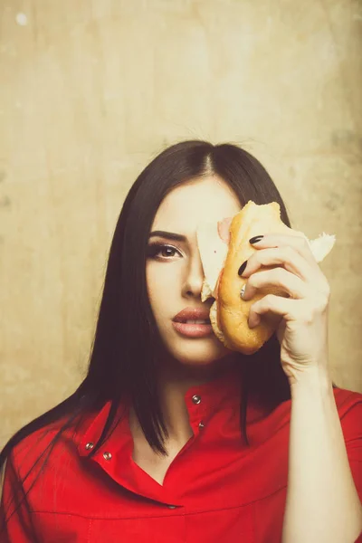 Seksi güzel esmer ciddi kadın büyük sandviç ya da hamburger yiyor — Stok fotoğraf