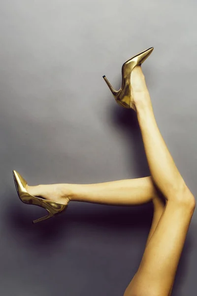 Female legs in golden shoes — Stock Photo, Image