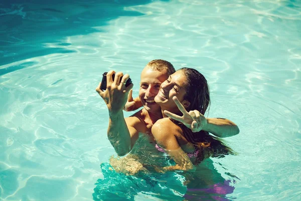 Gelukkige jonge paar bij zwembad — Stockfoto