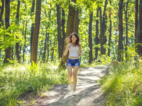Jeune femme runnin dans la forêt — Photo