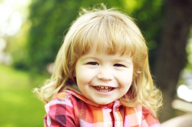 Yeşil doğal zemin üzerine mutlu küçük çocuk