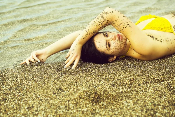 Bella ragazza si trova in costume da bagno giallo sulla spiaggia di mare — Foto Stock
