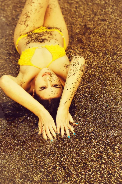 Menina bonita está em maiô amarelo na praia do mar — Fotografia de Stock