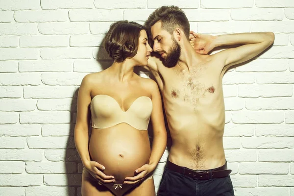 Бородатый худой мужчина и красивая беременная женщина с круглым животом — стоковое фото