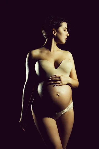 Pretty pregnant woman with round belly isolated on black — Stock Photo, Image