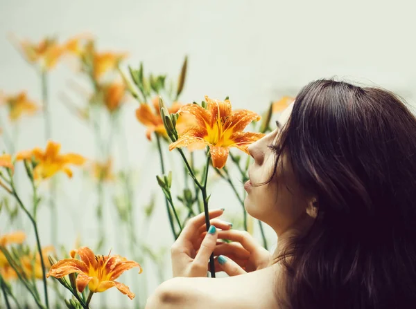 Mujer disfruta de naranja lirio flor —  Fotos de Stock