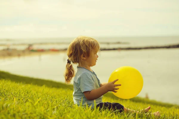 Bébé garçon mignon avec ballon jouet jaune — Photo