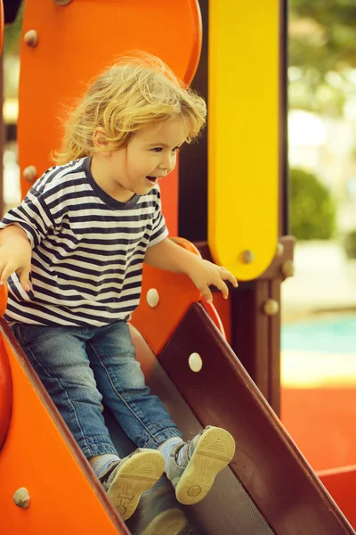 Χαριτωμένο μωρό ευτυχισμένο αγόρι βόλτες από πορτοκαλί slide σκάφους — Φωτογραφία Αρχείου