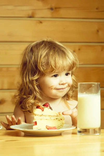 Kleine jongen met aardbeientaart en yoghurt — Stockfoto