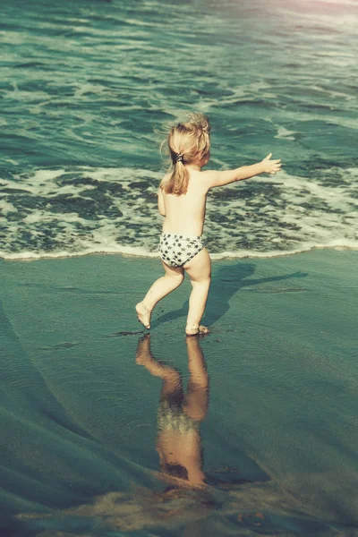 Islak kum deniz boyunca şirin neşeli bebek çocuk ishal