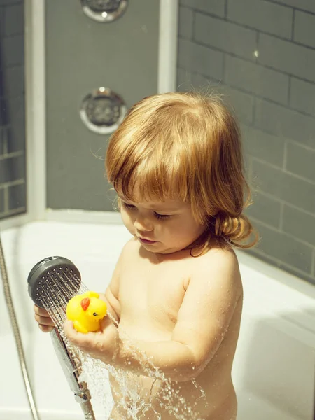 Мальчик с уткой в ванной — стоковое фото