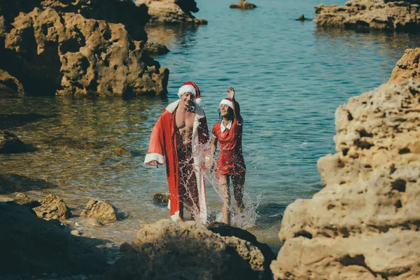 Kerst paar in het rood op strand. — Stockfoto
