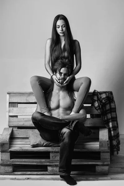 Junges Paar auf Holzsofa — Stockfoto