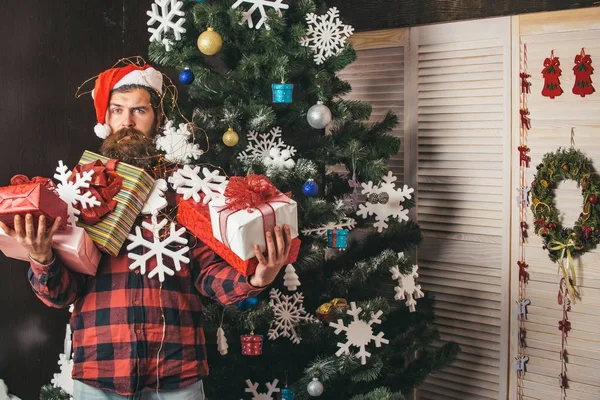 Boże Narodzenie człowieka z brodą, na twarzy przytrzymaj prezent. — Zdjęcie stockowe