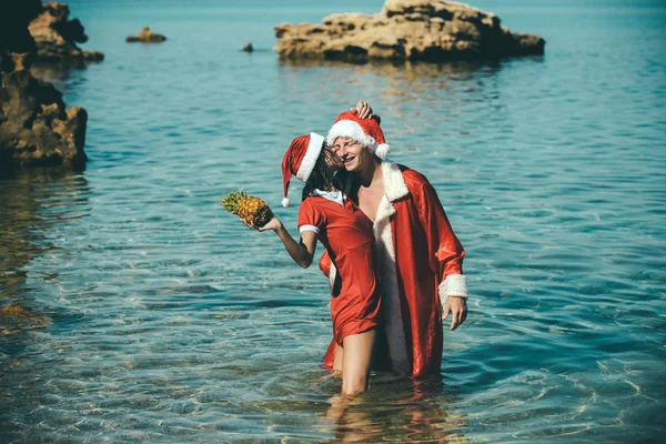 Neujahrsmädchen und -mann als roter Weihnachtsmann. — Stockfoto