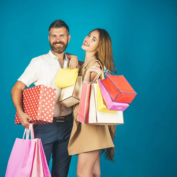 Pareja en amor mantenga bolsa de compras cerca de la pared azul . —  Fotos de Stock