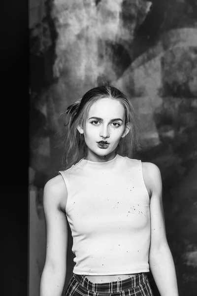 Симпатичная грязная девушка-маляр на окрашенной стене в черное — стоковое фото
