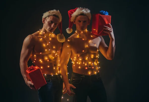 Twins santa z mięśni ciała w garland. — Zdjęcie stockowe