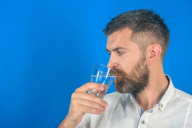 Uzun sakallı adam tutun su cam üzerinde mavi arka plan.