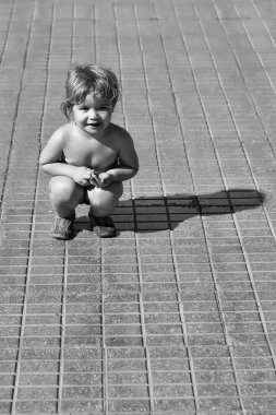 Şirin neşeli bebek çocuk kıç üzerinde oturur