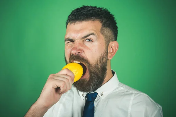 El hombre con barba larga come limón . — Foto de Stock