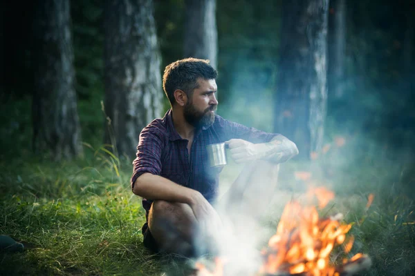 在森林篝火的时髦远足者与杯子放松 — 图库照片