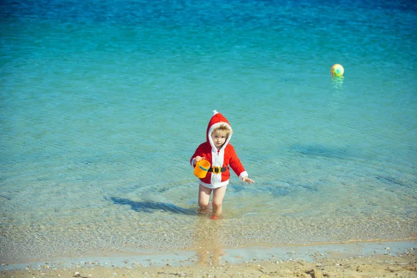 Año nuevo niño pequeño en la playa . — Foto de Stock